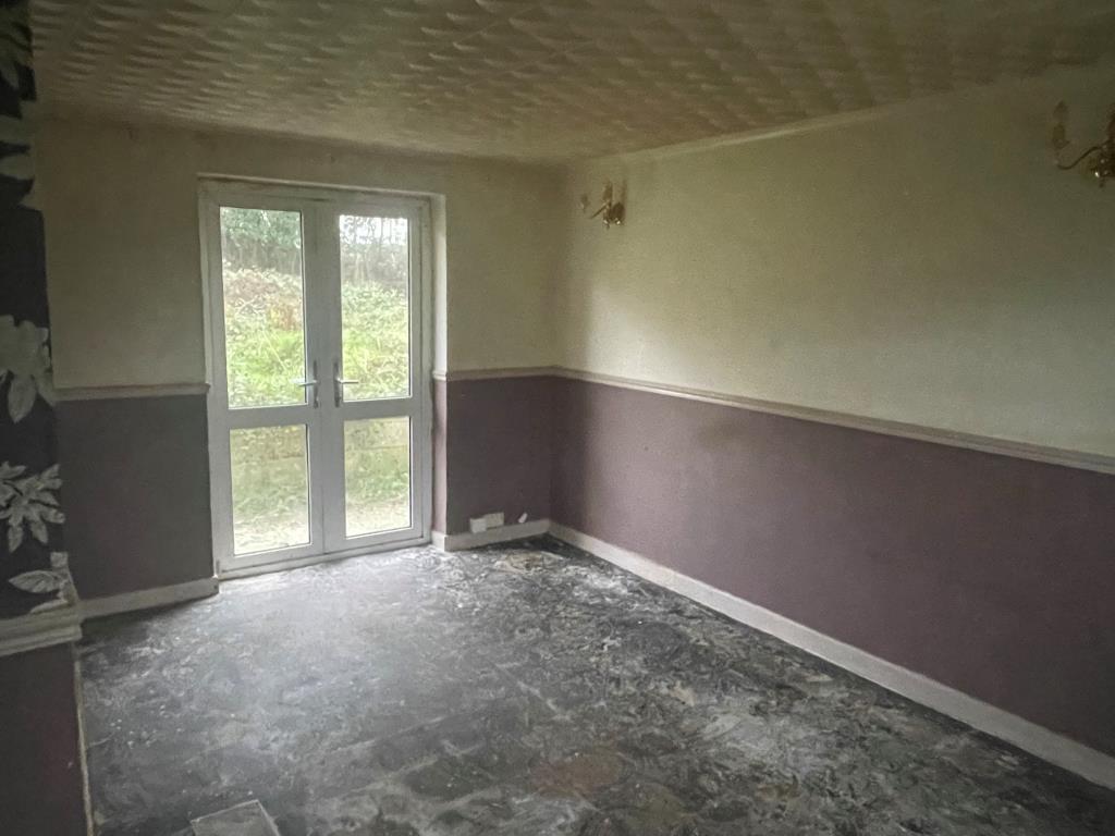 Lot: 135 - END-TERRACE HOUSE WITH GARAGE - Living room with doors leading to rear